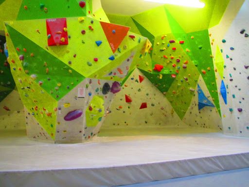Palestra di arrampicata con pareti colorate in verde e arancione